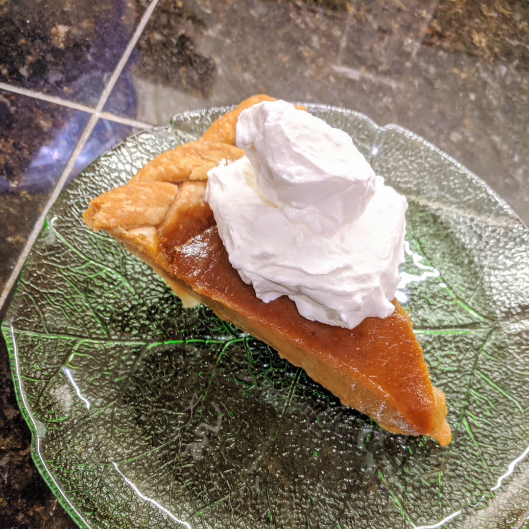 A slice of pumpkin pie with whipped cream