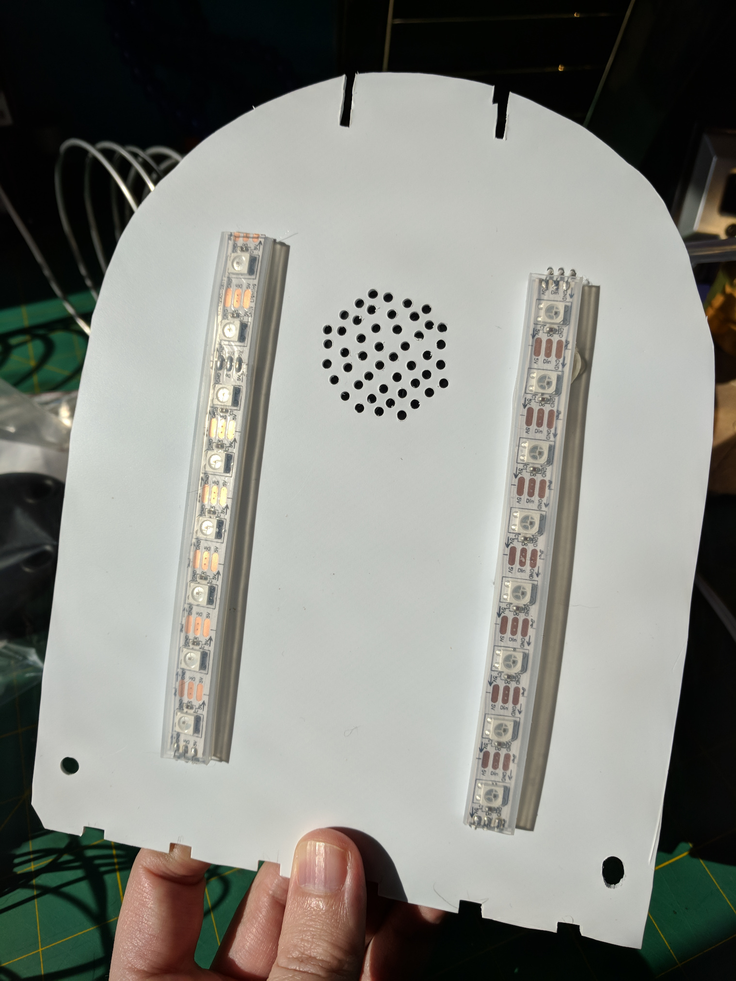 Polystyrine cut in the shape of a mailbox cross-section with mounted LEDs and small holes to form a speaker grille.