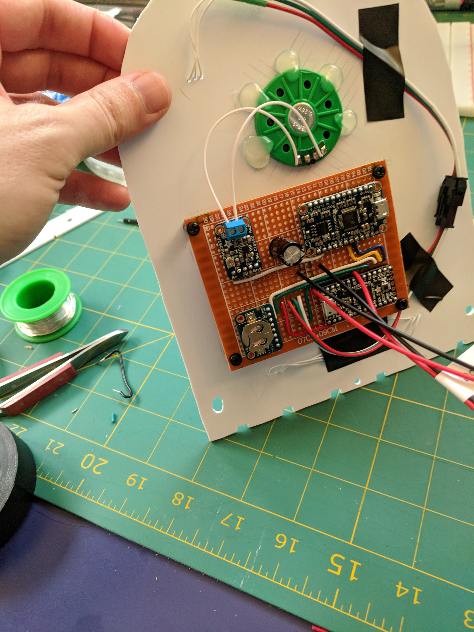 Protoboard with components mounted on the back of the backplate with a speaker and wires.