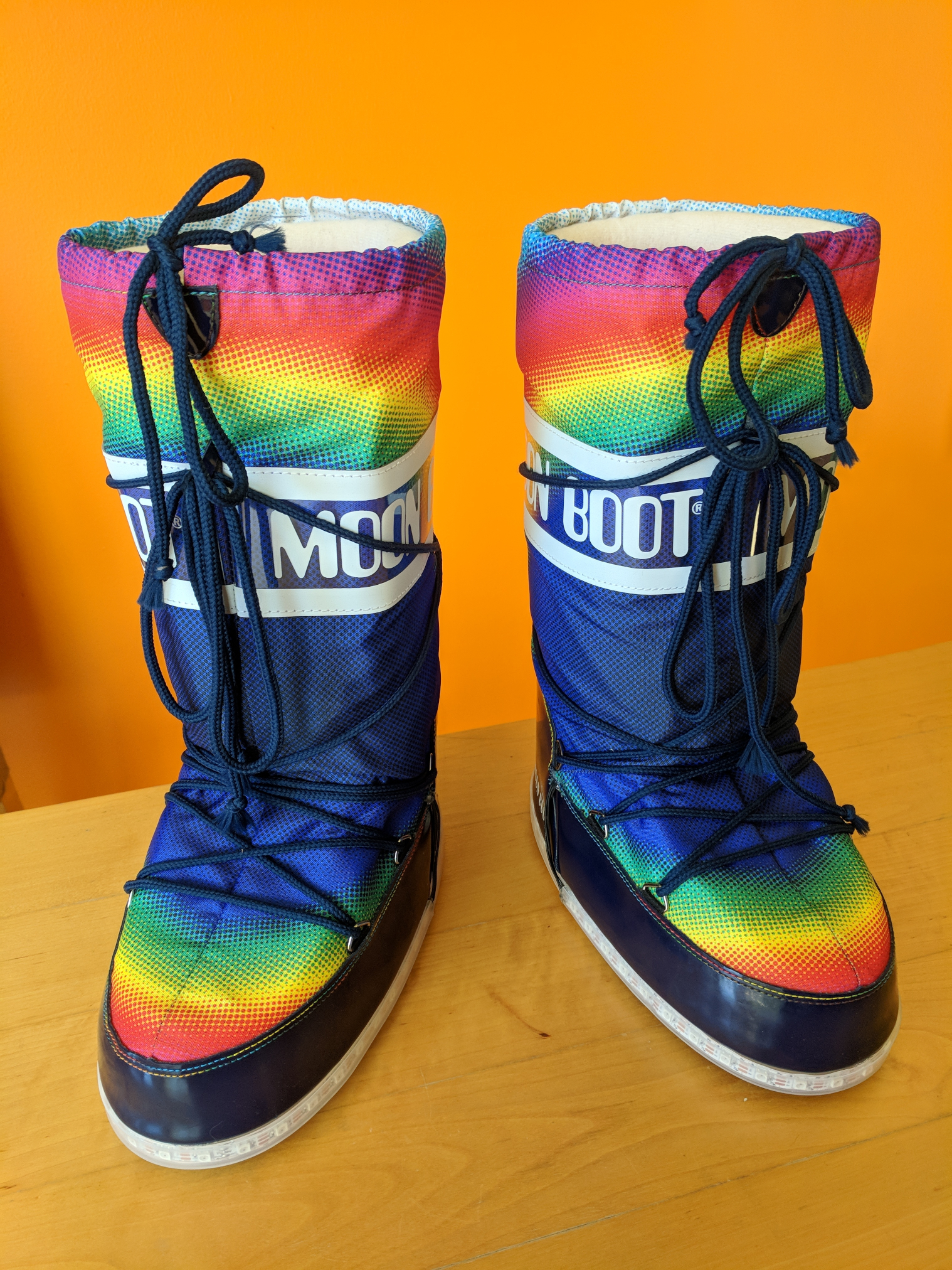 A pair of rainbow moon boots with LED strips around the edge of the soles.