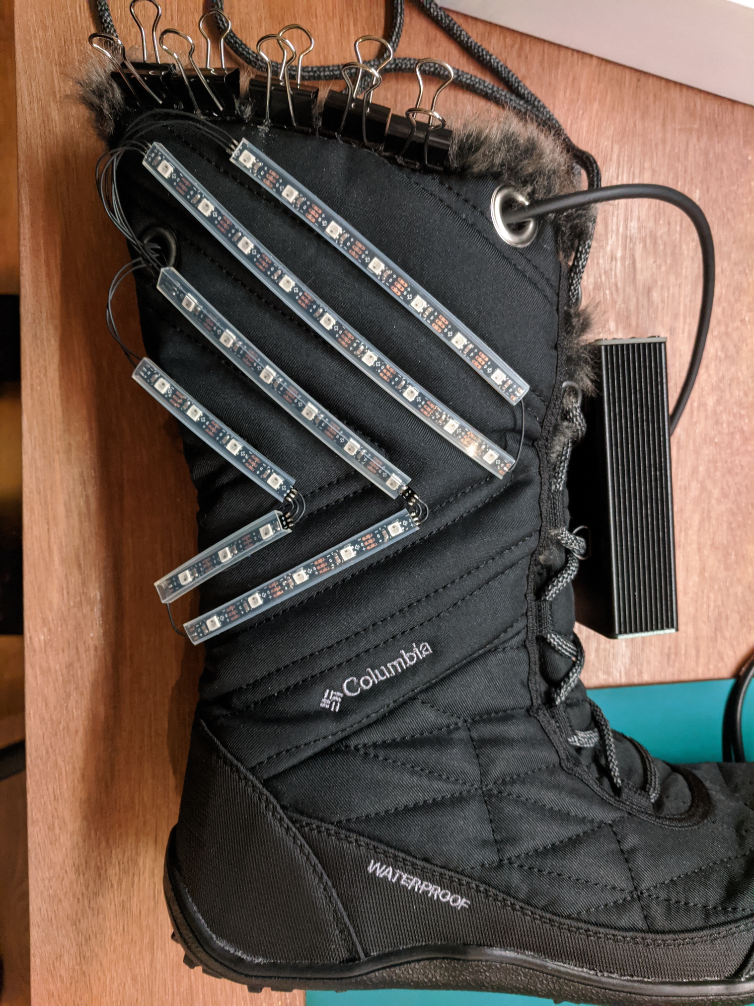 A boot, on its side, with LED strips laid out for mounting.