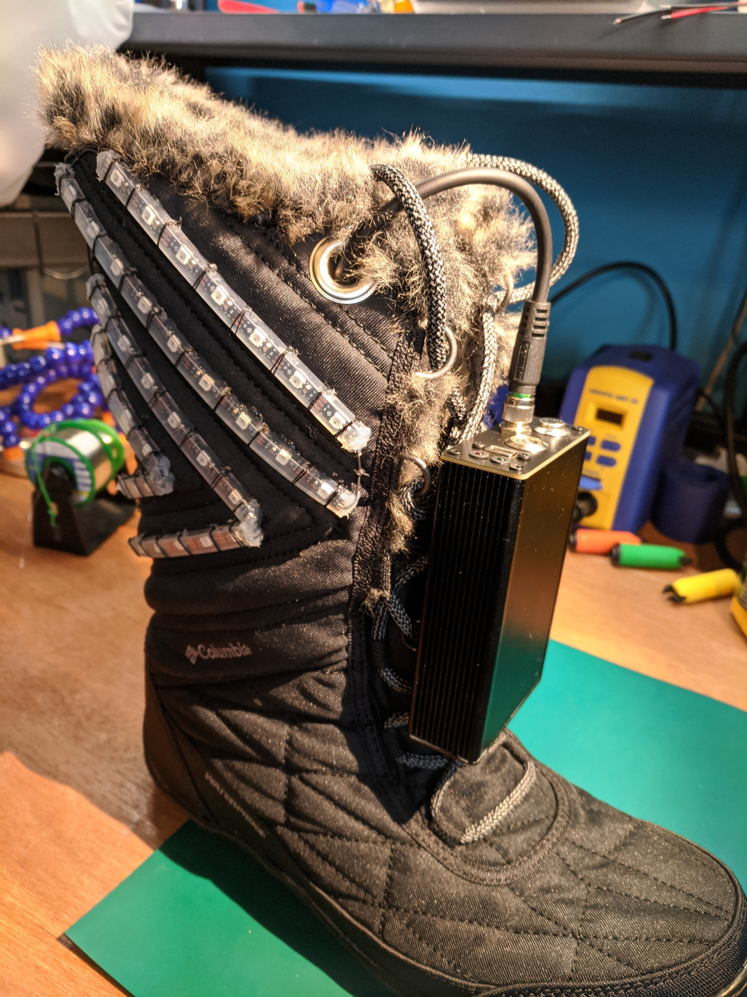 Boot with mounted LED strips on the side and enclosure mounted over othe laces.