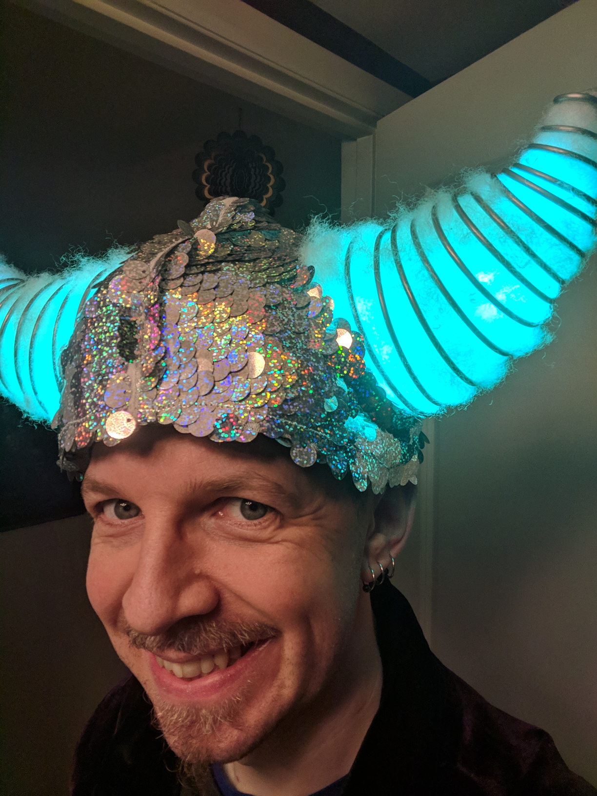 Head shot of Habib smiling wearing the completed helmet with horns glowing.