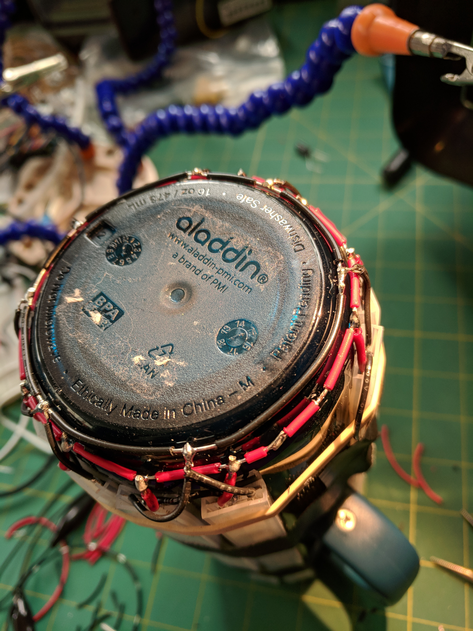 Close up of the bottom of the water bottle and LED strips showing power and ground LED connections in a ring, neatly trimmed.