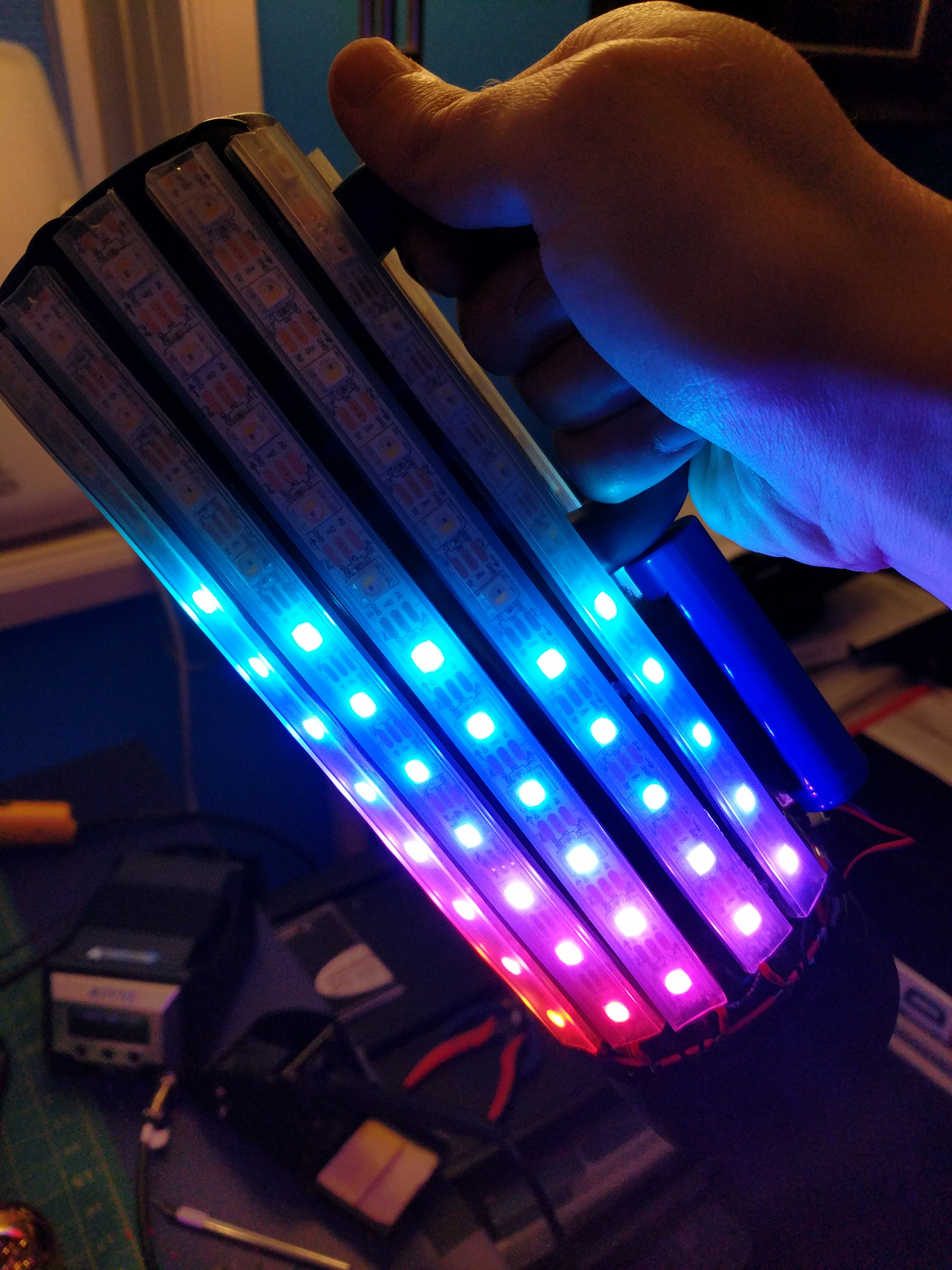 The water bottle, held at an agle, with LEDs slit in a rainbow representing virtual fluid